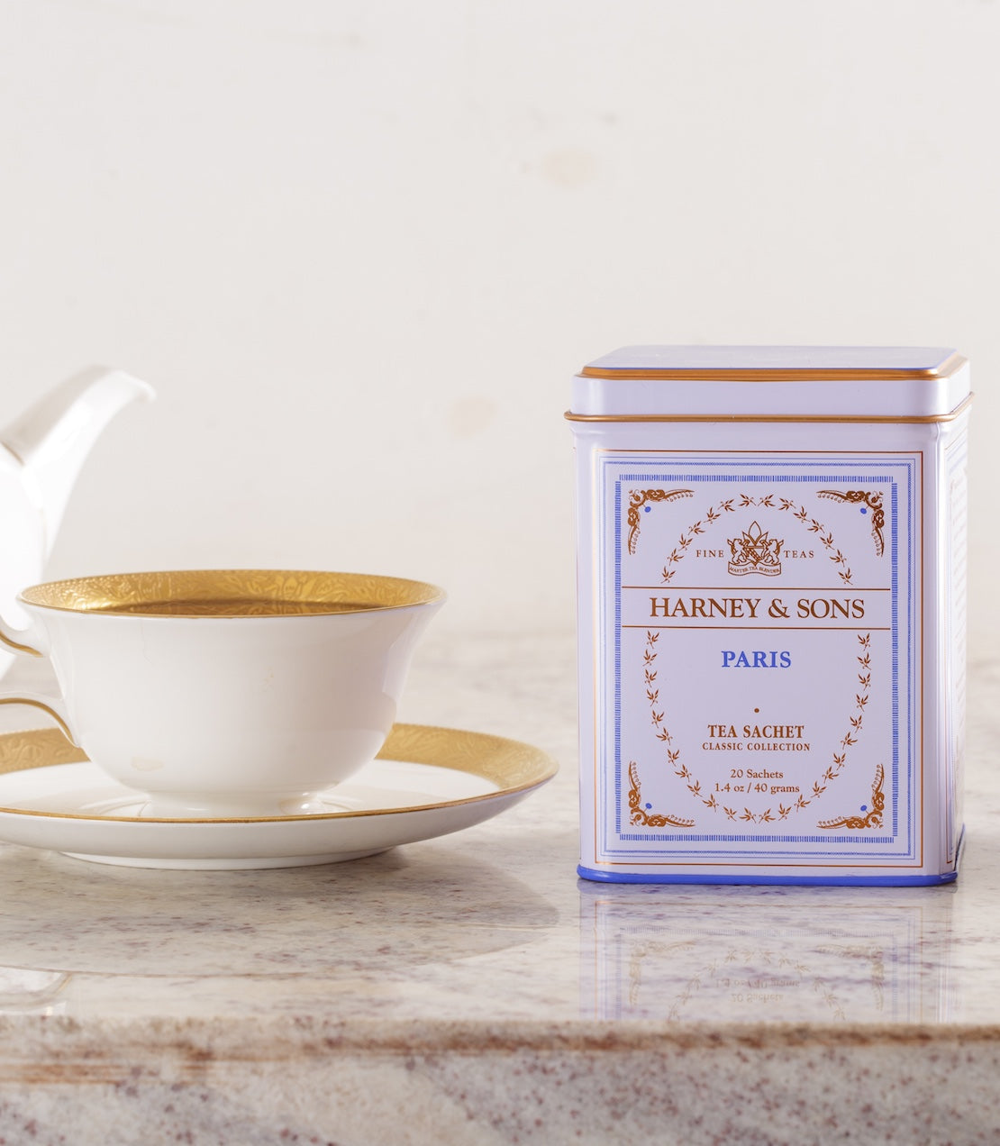 Harney & Sons Paris Classic tea tin with a teacup and saucer on a marble surface.