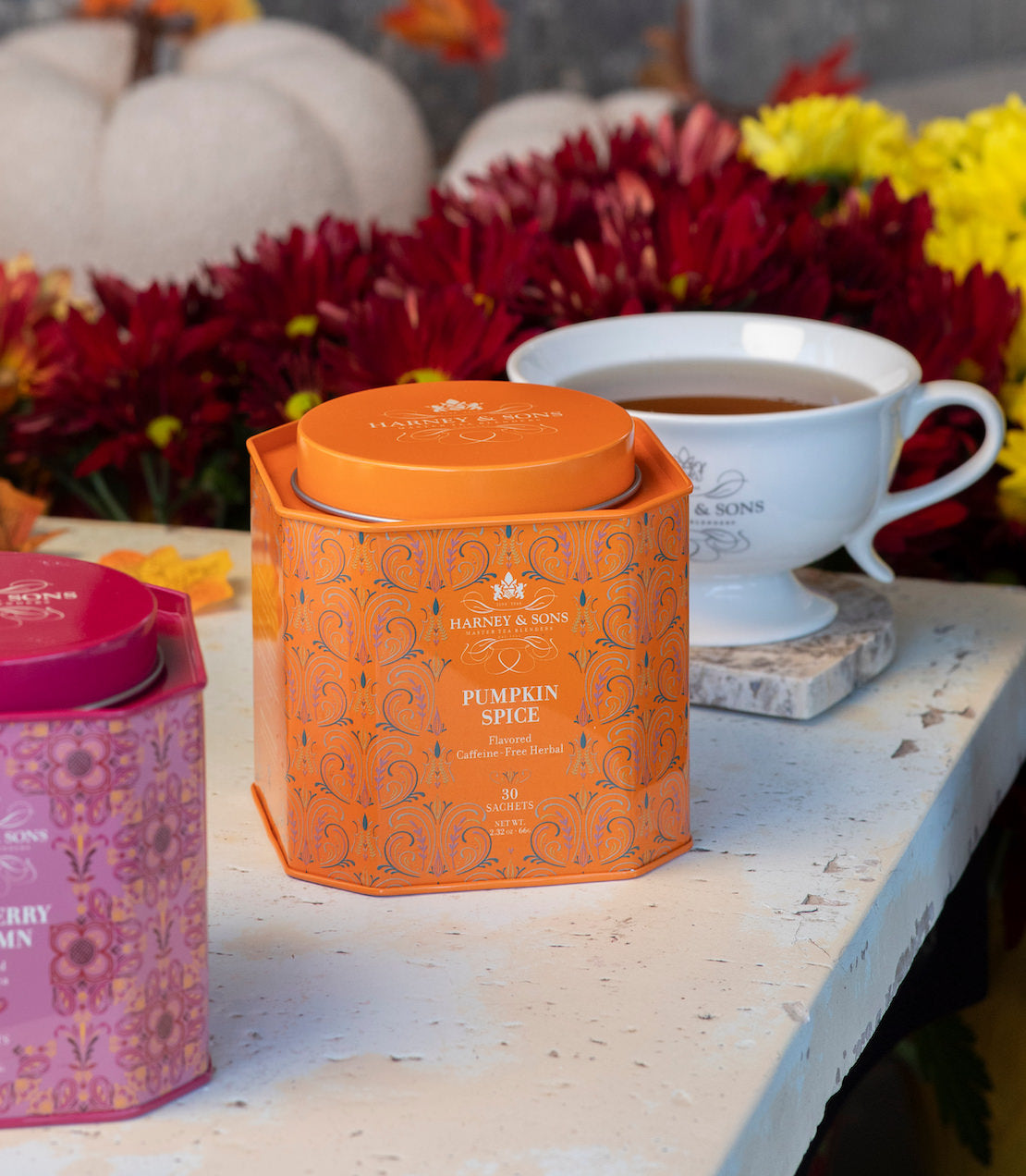 Pumpkin spice 30 ct tea tin with a white tea cup on a table with fall decorations.