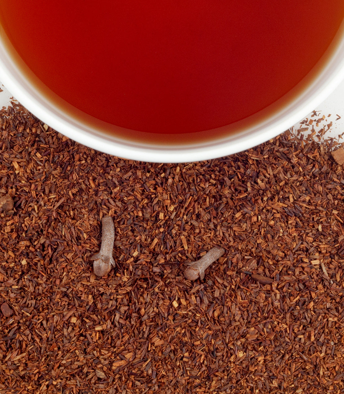 "Pumpkin spice tea sachets in a tin, with brewed tea and loose tea leaves scattered on a surface.