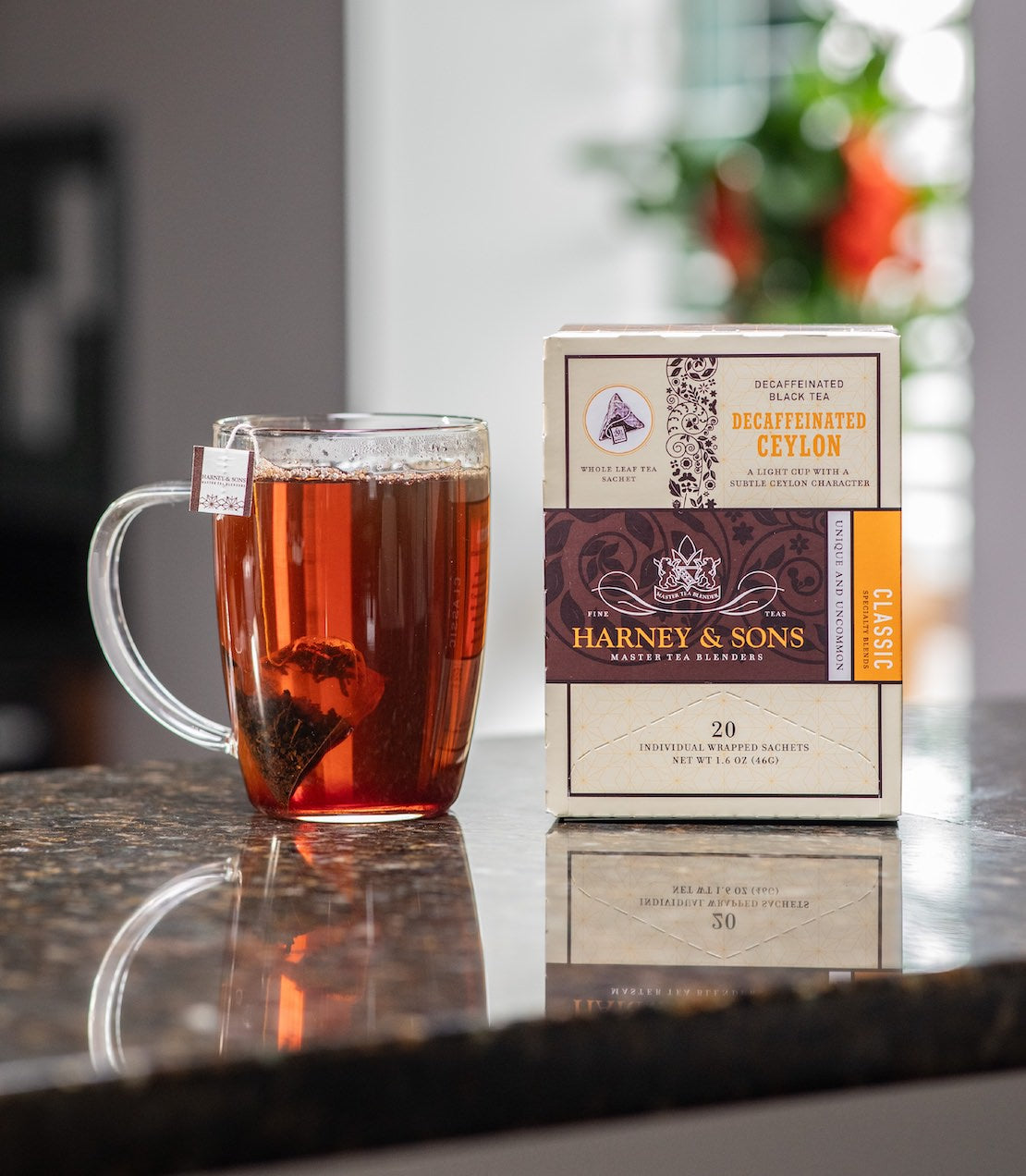 Tea cup with Harney & Sons decaf Ceylon tea bag box on a reflective surface