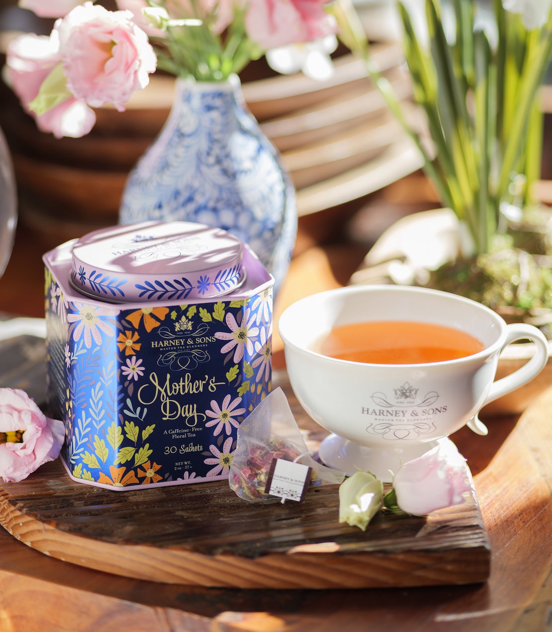 Harney & Sons Mother's Day tea set with a teacup and floral packaging on a wooden tray.