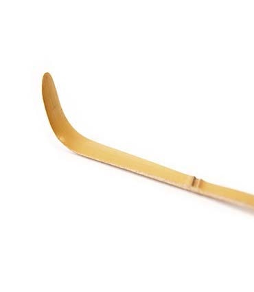 Bamboo matcha scoop with a curved design for precise tea measurement and serving. Eco-friendly kitchen tool.