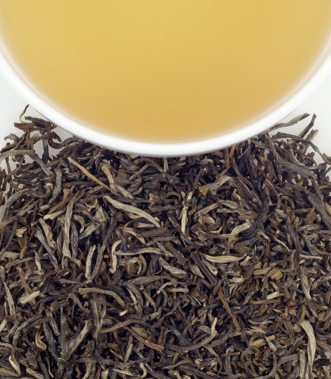 Jasmine tea sachets in a bag of 50, with brewed tea in a cup above loose tea leaves.